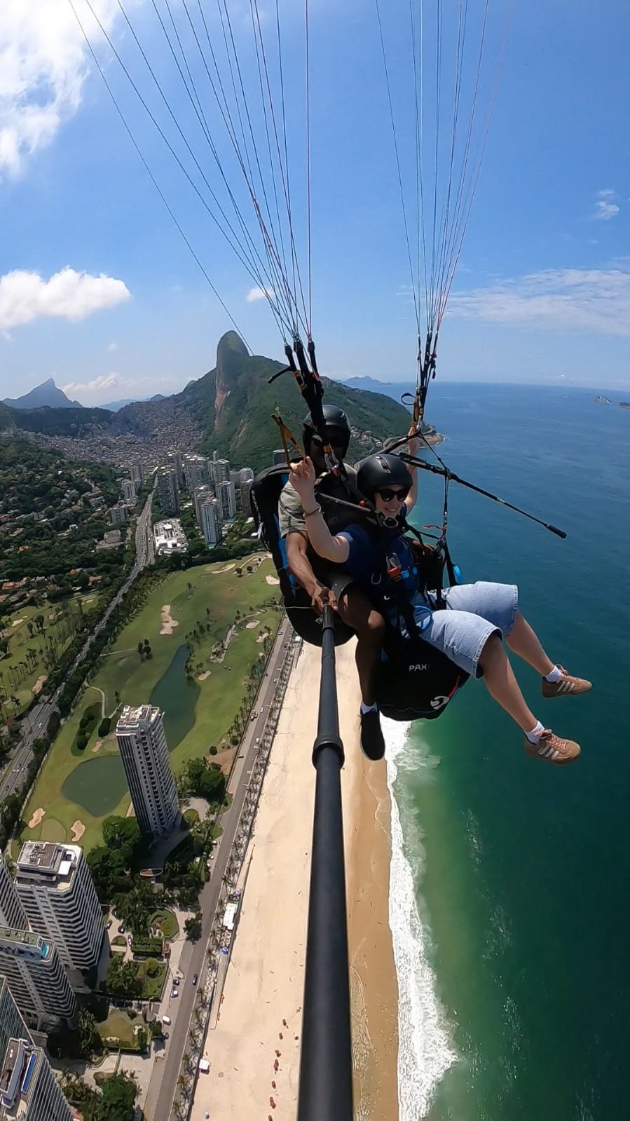 Vista aérea do Rio de Janeiro durante o voo de parapente, com praia, mata e montanhas