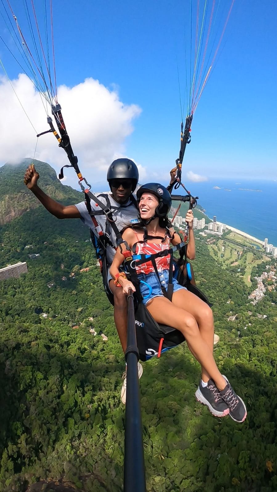 Passageira sorrindo durante o voo duplo de parapente sobre o Rio de Janeiro