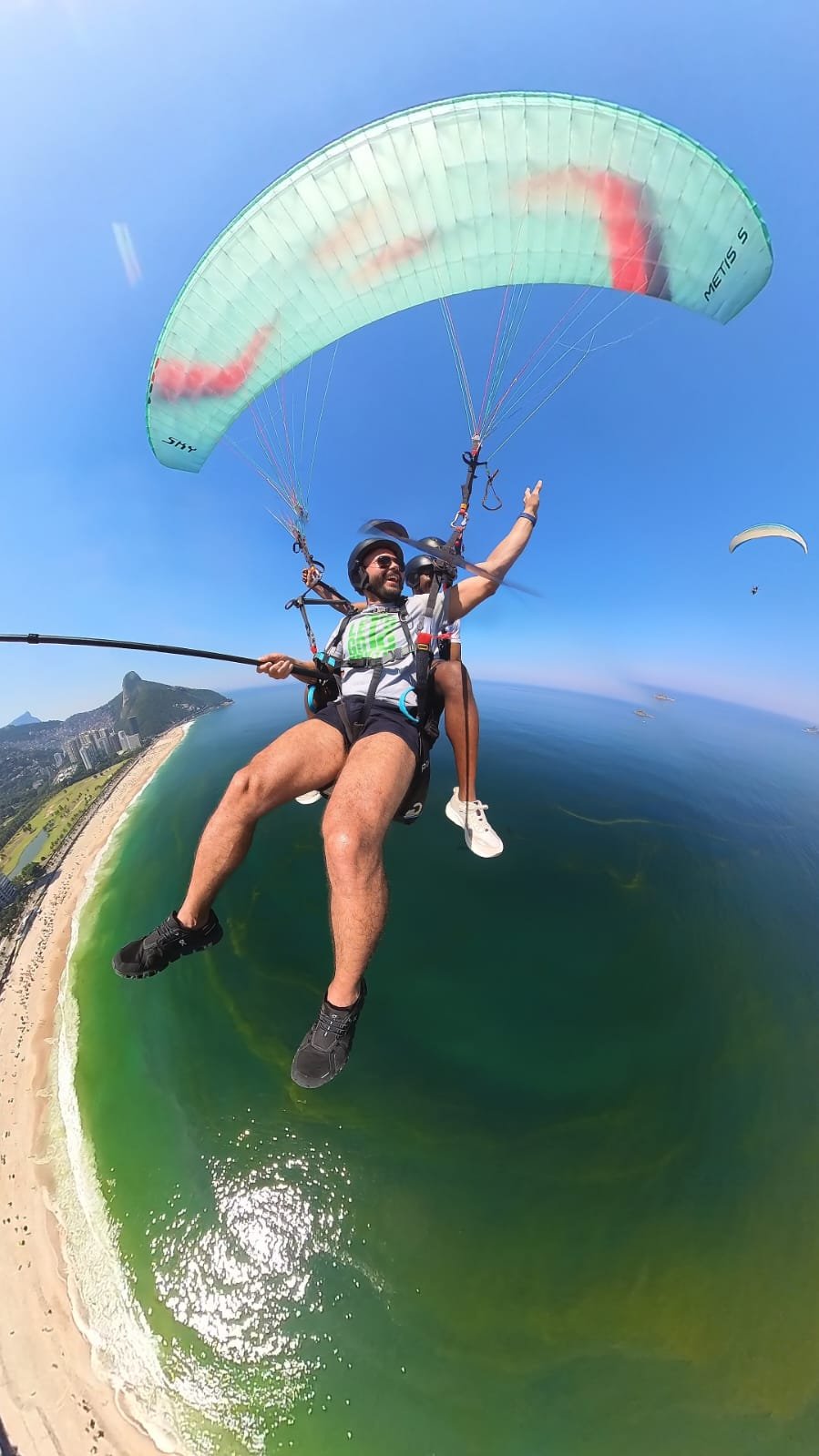 Passageiro em voo de parapente sobre o mar no Rio de Janeiro