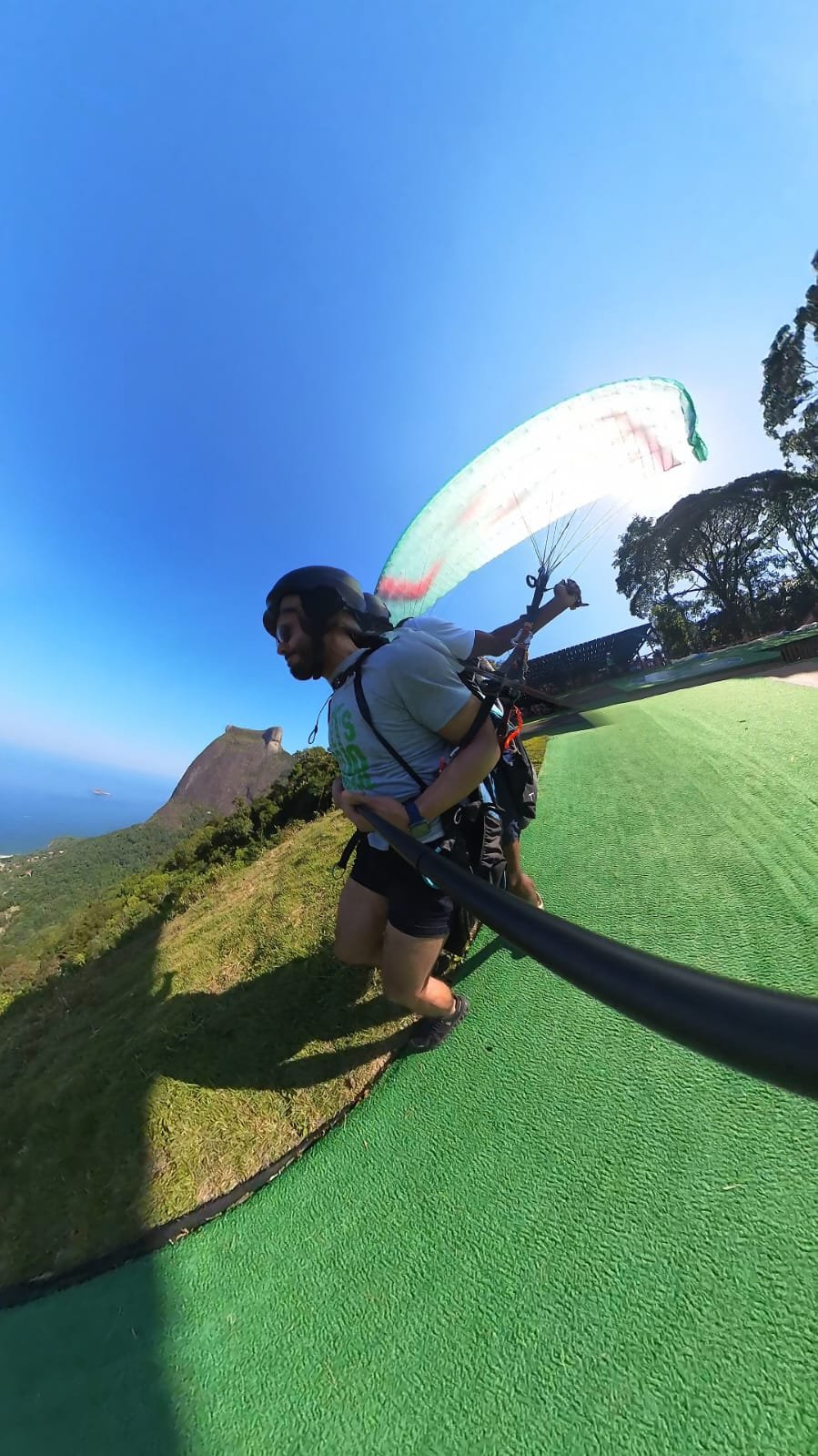 Passageiro e instrutor durante a decolagem de parapente no Rio de Janeiro